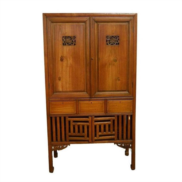 Brown wooden Chinese kitchen cabinet with hand-carved details, two doors, and three drawers, front view.