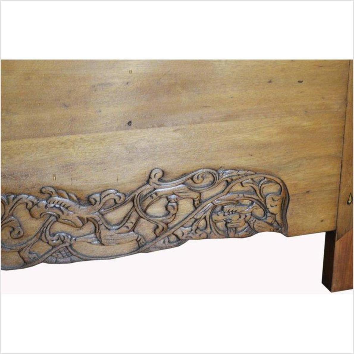 Light brown wood Chinese lacquered cabinet doors with swirling floral and leaf patterns, close-up view.