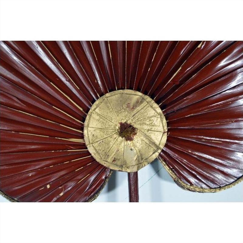 Close-up of maroon and gold antique Chinese fabric flags with pleats on a light background.