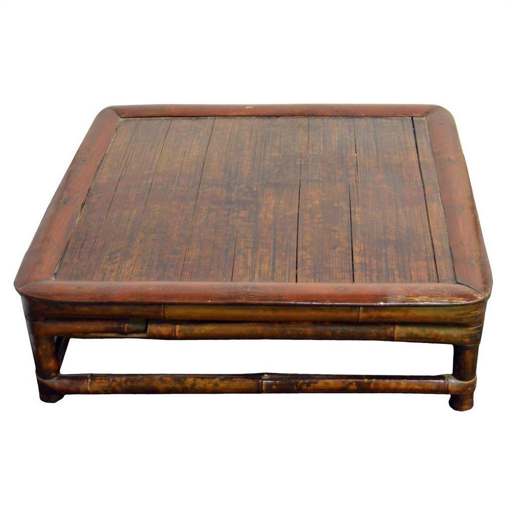 Brown wood square Chinese low kang ceremonial table with flat top, rounded edges, and short legs on plain background.