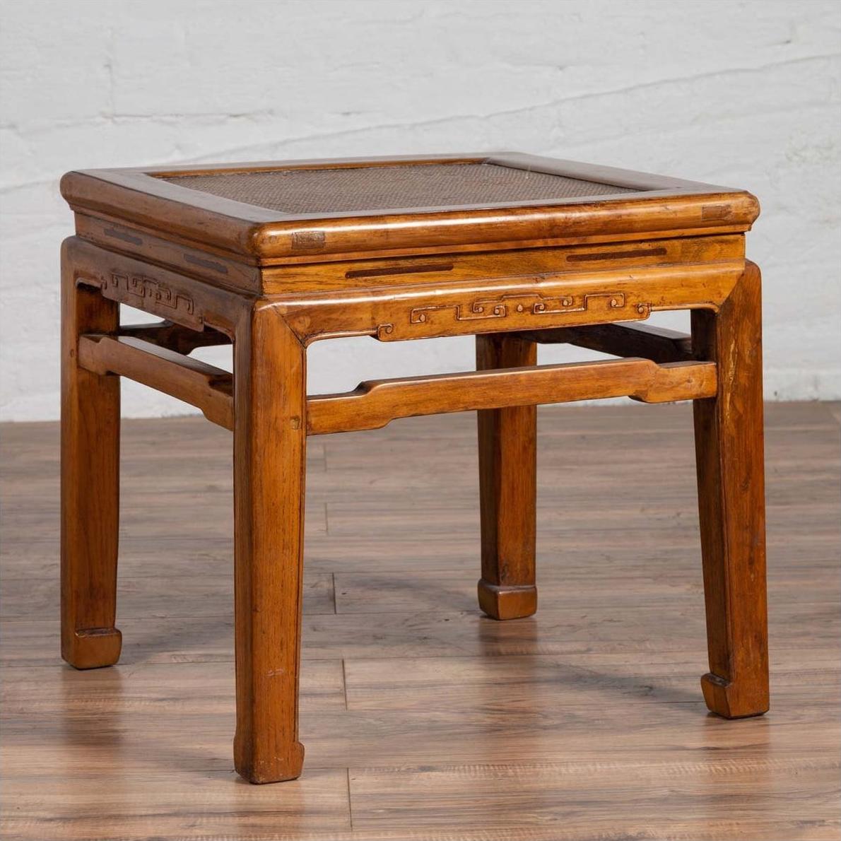 Brown elmwood Ming style side table with horsehoof legs and woven rattan seat, waisted design, close-up view.