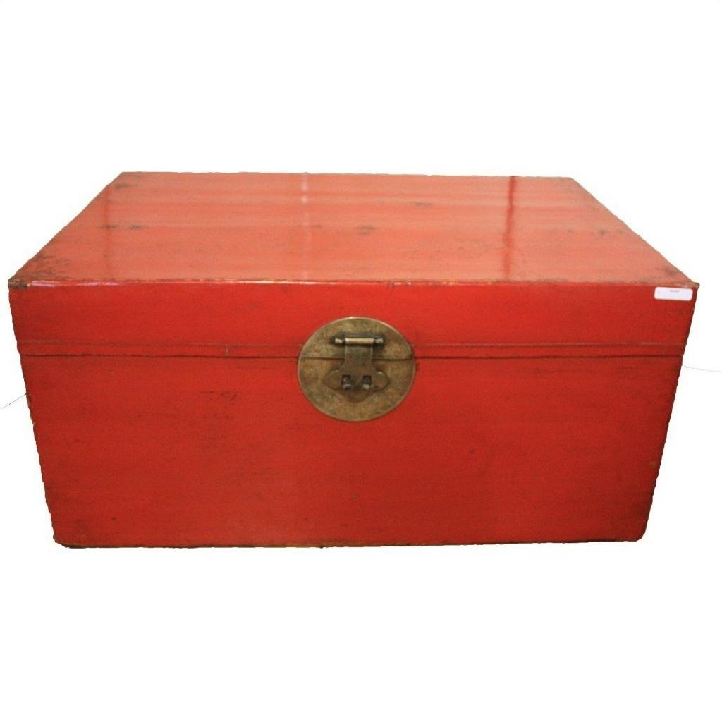 Red lacquered antique Chinese blanket chest with brass lock, on plain white background.