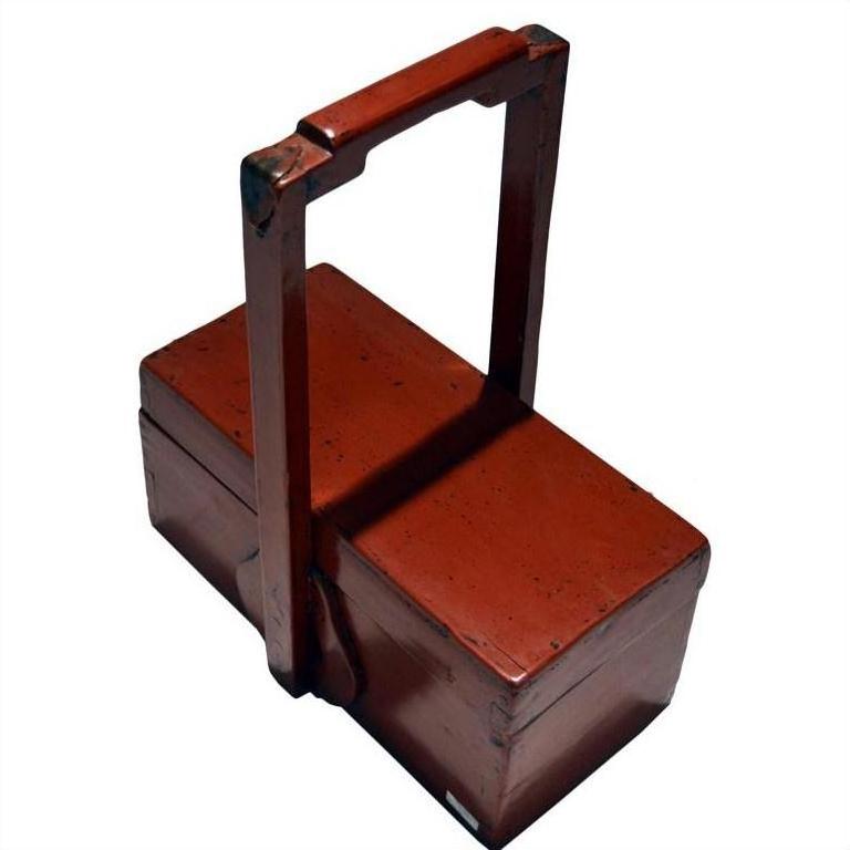 Red lacquer wood box with rectangular shape and tall handle, antique Chinese style, close-up view.