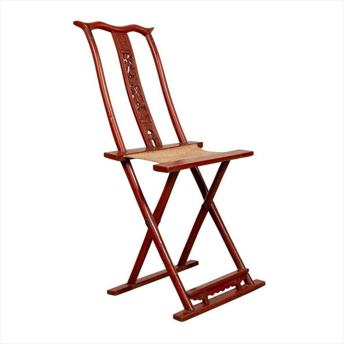 Red lacquered wood folding chair with footrest and fabric, antique Chinese style, on white background.