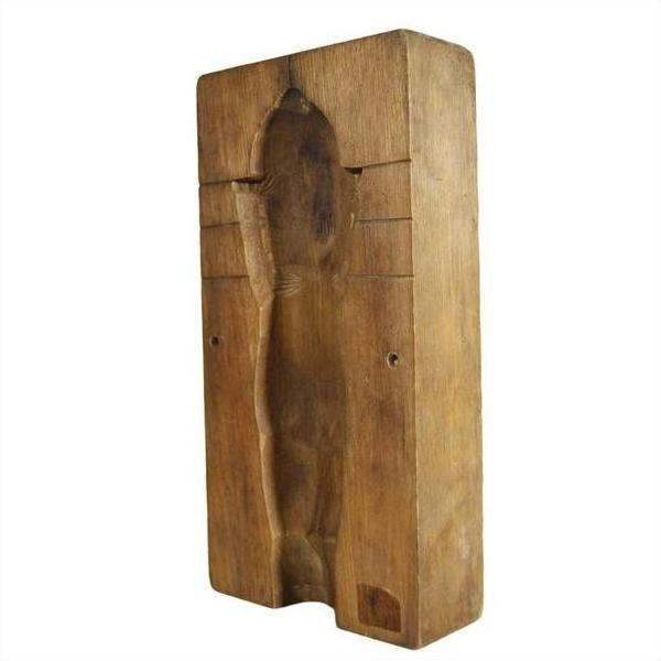 Close-up of an antique wooden Chinese rice mold, rectangular, carved with a hollowed-out human figure in the center.