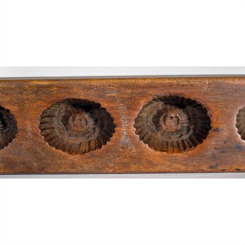 Close-up of an antique Chinese rice mold with scalloped, circular indentations, ceramic material.