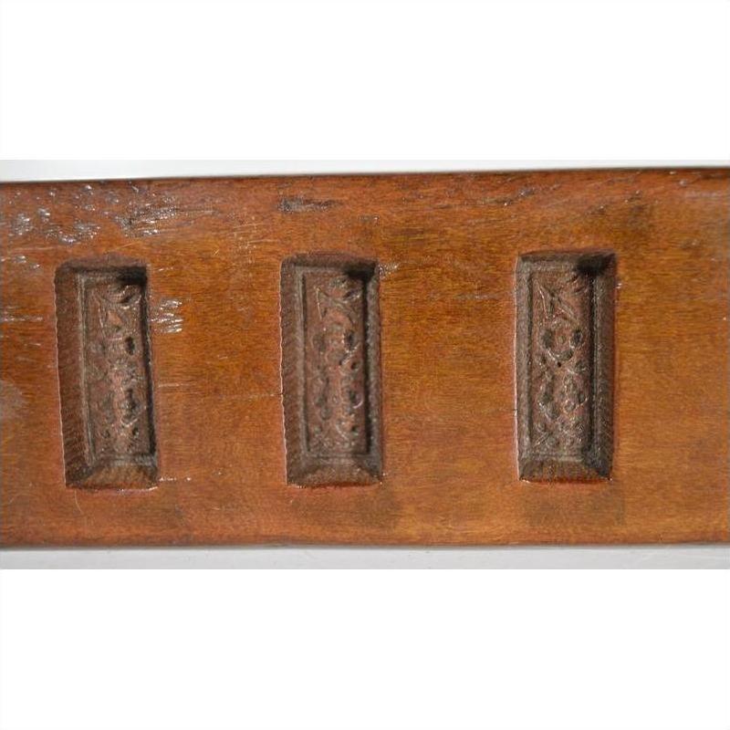 Brown wooden antique Chinese rice molds with carved geometric designs, close-up on smooth surfaces.