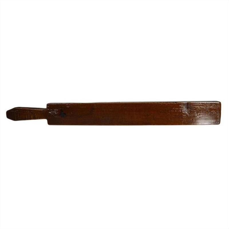 Close-up of antique Chinese rice mold, flat rectangular wooden paddle with small handle on the left side, wood texture.