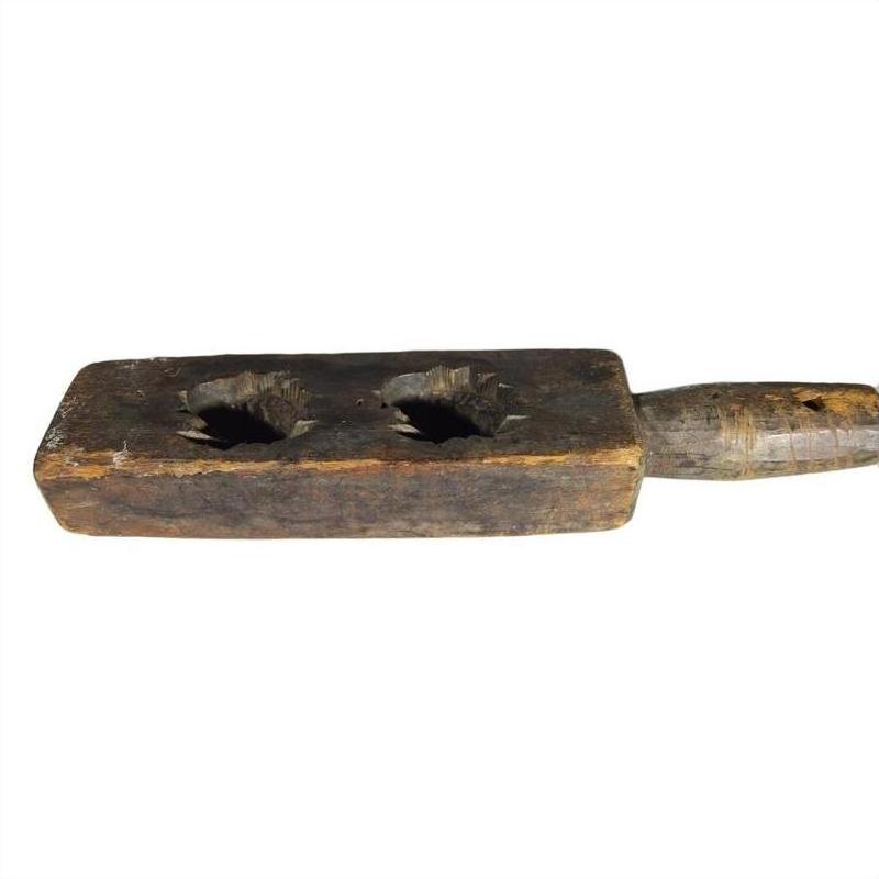 Brown wooden antique Chinese rice mold with two large holes and handle, isolated on white background, close-up.