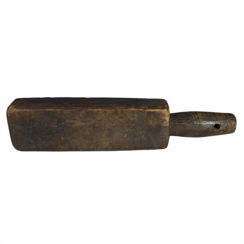 Close-up of rectangular wooden Chinese rice mold with short handle, antique style, resting on a surface.