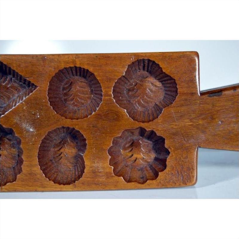Brown wooden antique Chinese rice mold with geometric eight-shape design, used for traditional cookies or sweets.