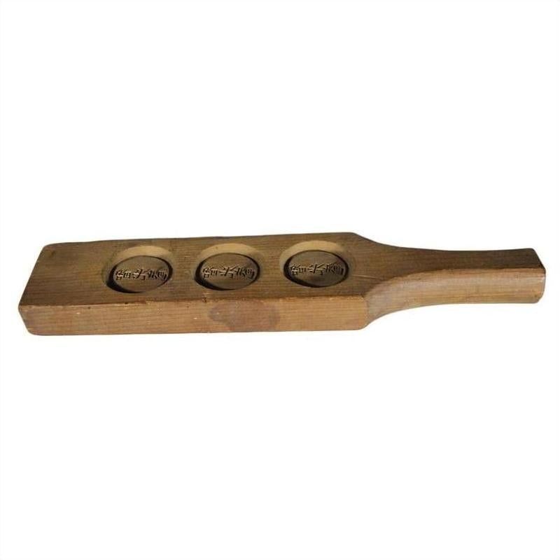 Light wood antique Chinese rice mold with three round character stamps, close-up.