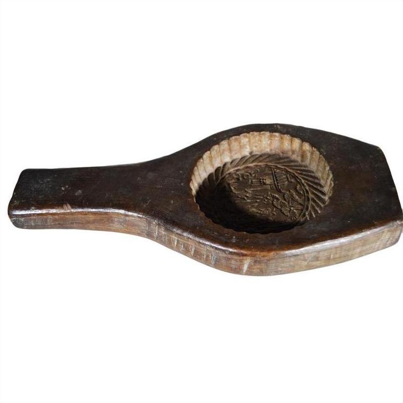Brown wood Chinese rice mold with round motif, braided rim, carved handle, and floral design, close-up view.