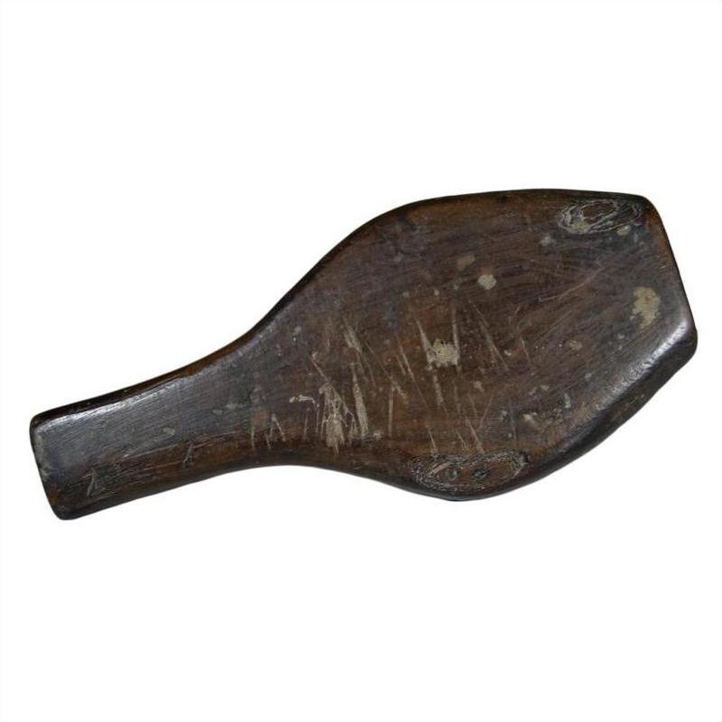 Brown wood antique Chinese rice mold with round motif and braided rim, visible wear, close-up on plain background.
