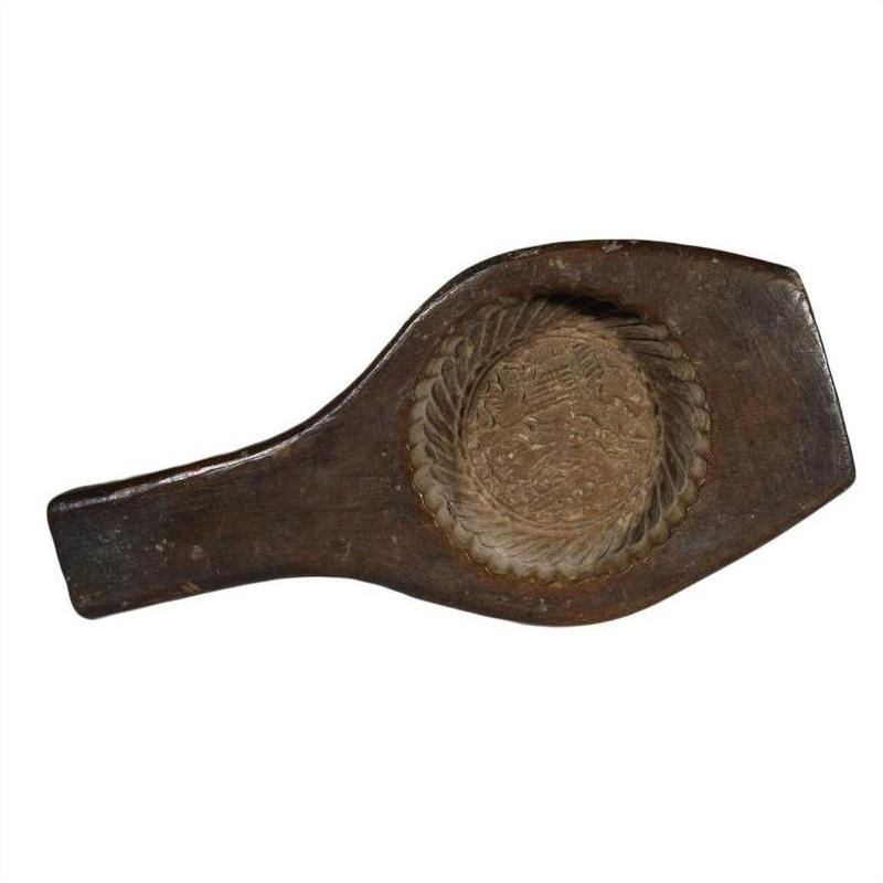 Brown wooden antique Chinese rice mold with handle, single round motif, and braided rim, close-up on white background.