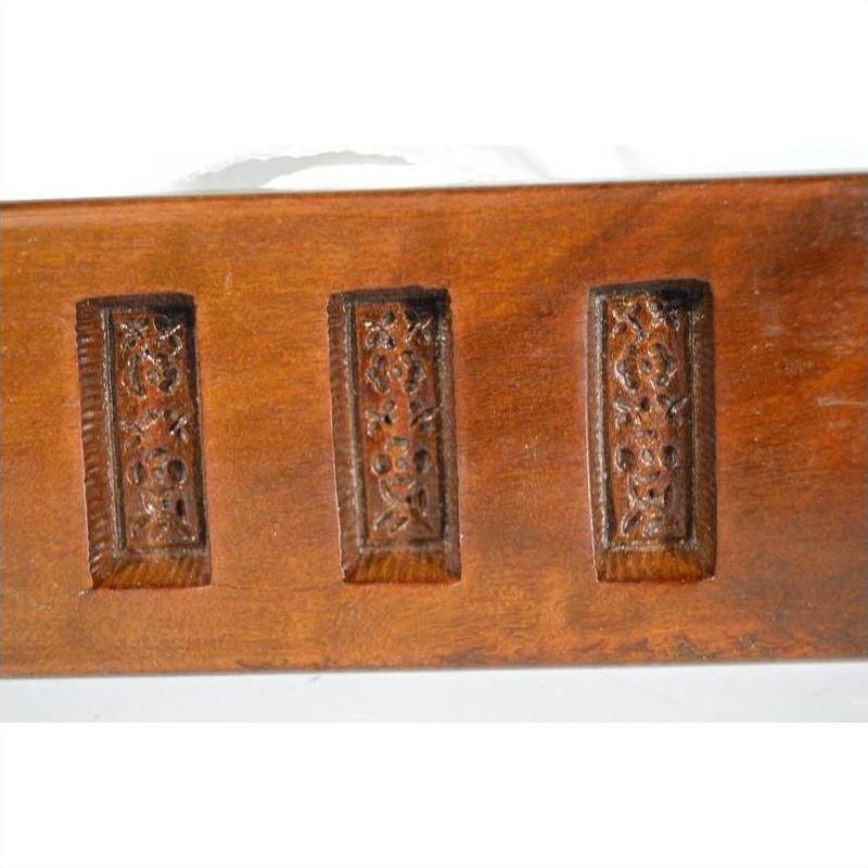 Brown antique Chinese wooden rice mold with five rectangular character cavities, close-up on a plain background.