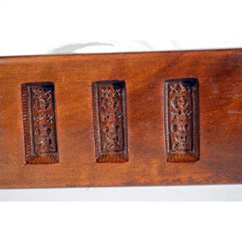 Close-up of antique wooden Chinese rice mold showing five rectangular character carvings.