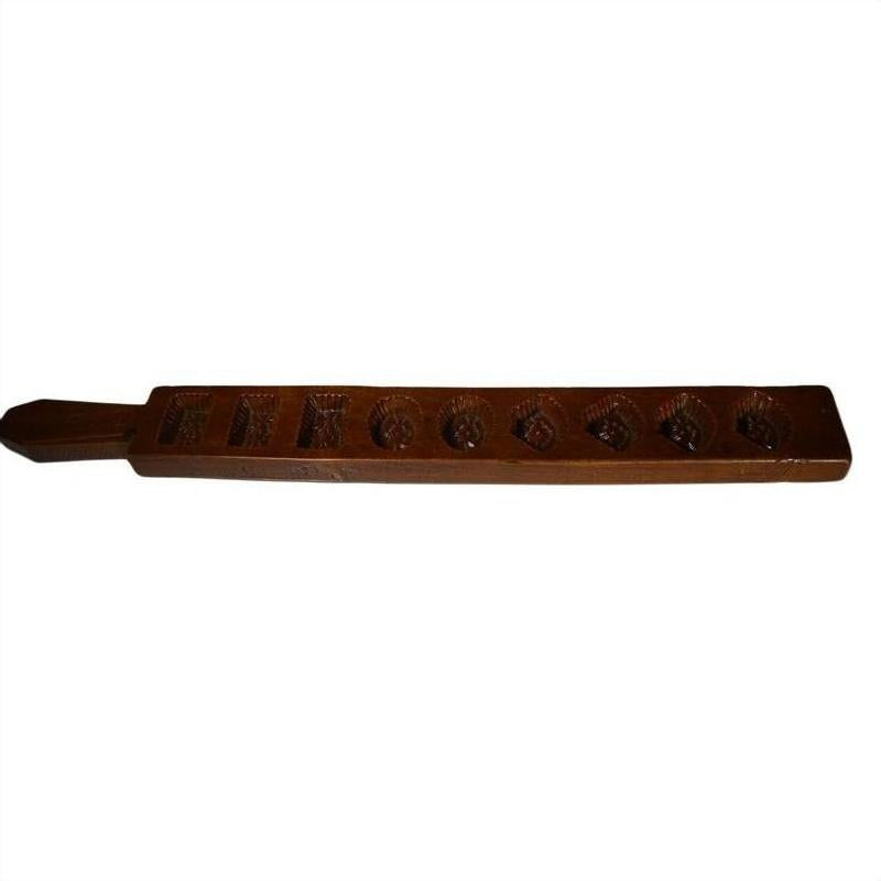 Close-up of an antique wooden Chinese rice mold with seven rectangular cavities and mixed carved motifs.