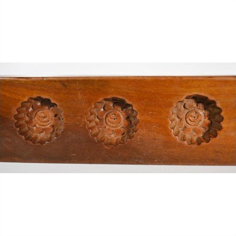 Close-up of dark wood antique Chinese rice mold with five spiral floral cavities.