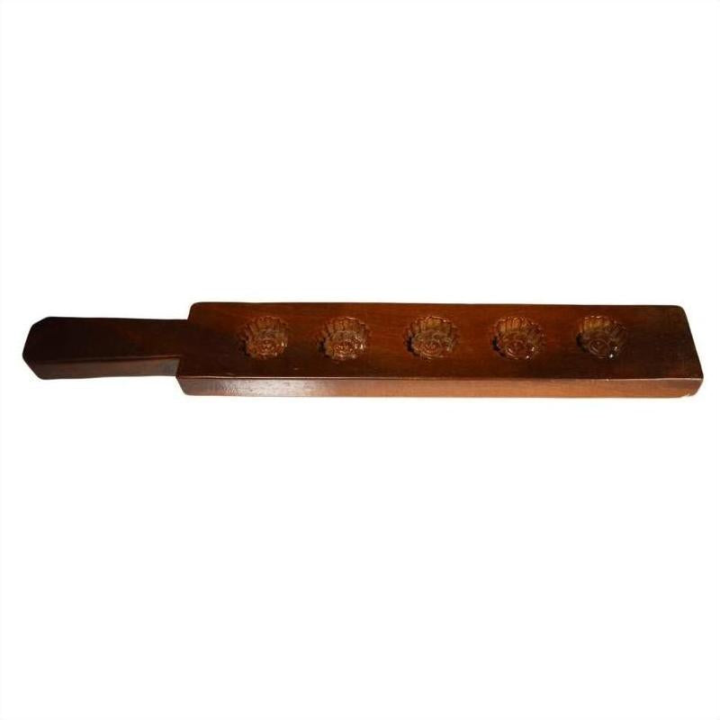 Dark wood antique Chinese rice mold with five spiral floral spiral cavities on a white background.