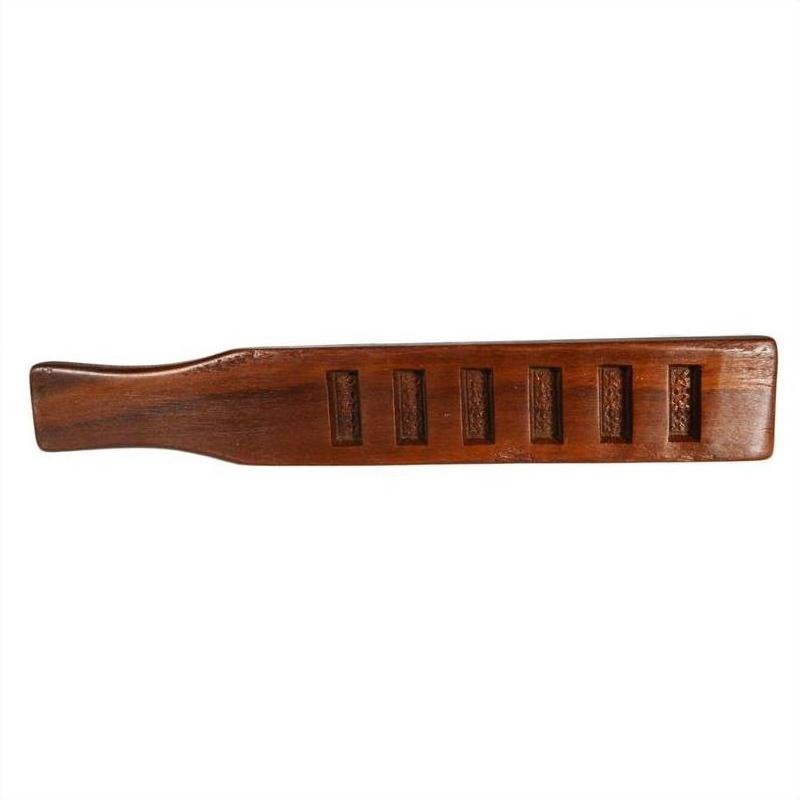 Close-up of antique wooden Chinese rice mold paddle with six character-shaped cavities and a curved form.
