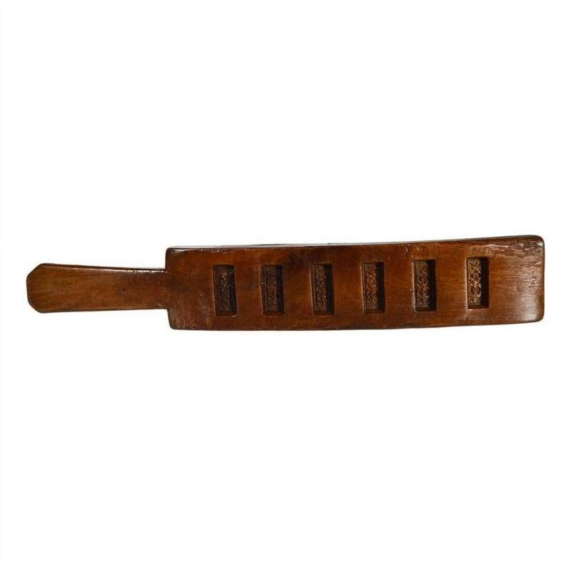 Dark-finished antique Chinese rice mold with six rectangular seal carvings, close-up view.