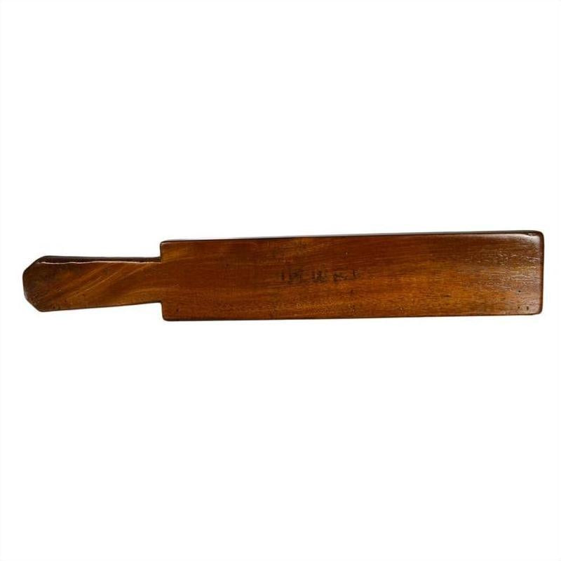 Walnut finish wooden antique Chinese rice mold in solid paddle form, close-up on white background.