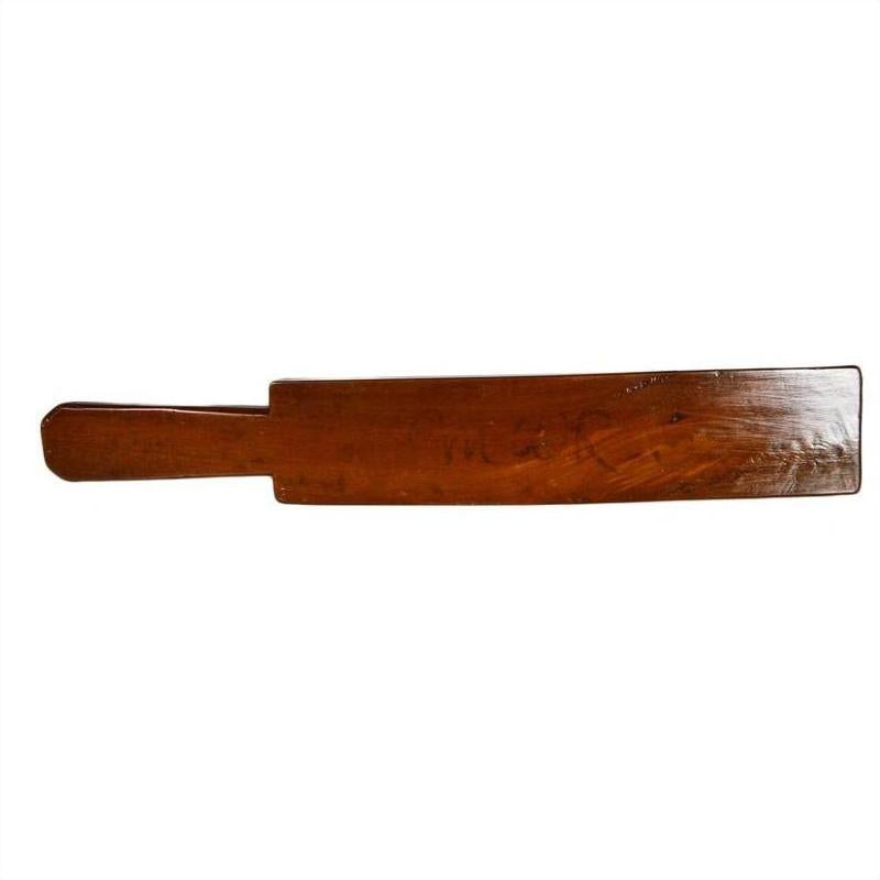 Brown wood antique Chinese rice mold with four rosette cavities and long handle on plain white background.