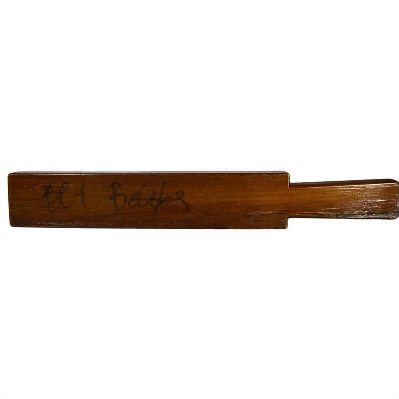 Brown wooden antique Chinese rice mold with four round seal cavities and carved calligraphy detail, close-up view.