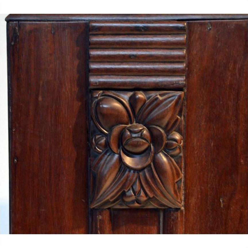 Close-up of dark rosewood side table with floral design and horizontal grooves above the flower.