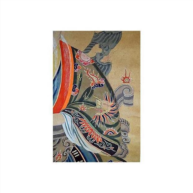 Close-up of colorful dragon and flame robe detail on an antique Chinese scroll painting with decorative background.