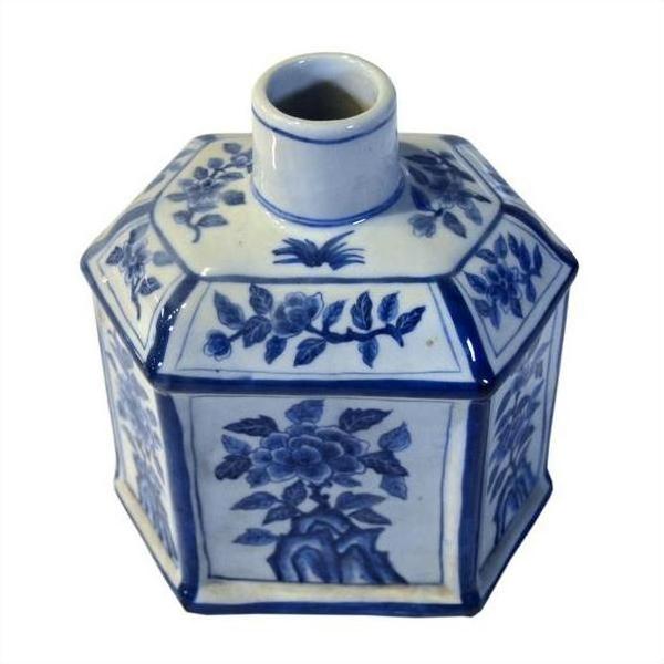 Blue and white ceramic sake bottle with hand painted floral design, narrow neck, close-up on white background.