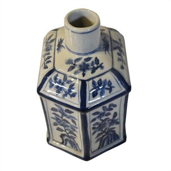 Blue and white ceramic hexagonal sake bottle with hand-painted floral designs, narrow neck, top view.