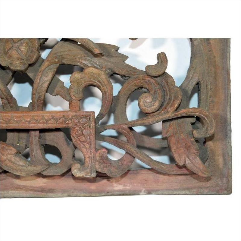 Close-up of antique Chinese wood temple carving with intricate floral and scrollwork patterns, delicate detailed design.