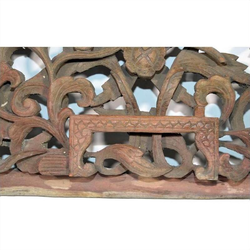 Close-up of antique wooden Chinese temple carving with intricate floral and leaf patterns, empty rectangular center frame.