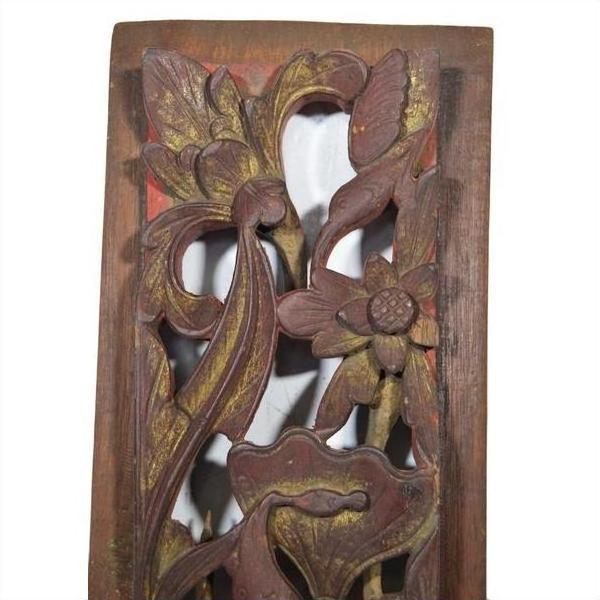 Reddish-brown wood Chinese carving close-up with vertical peony spray, detailed floral and leaf motifs.