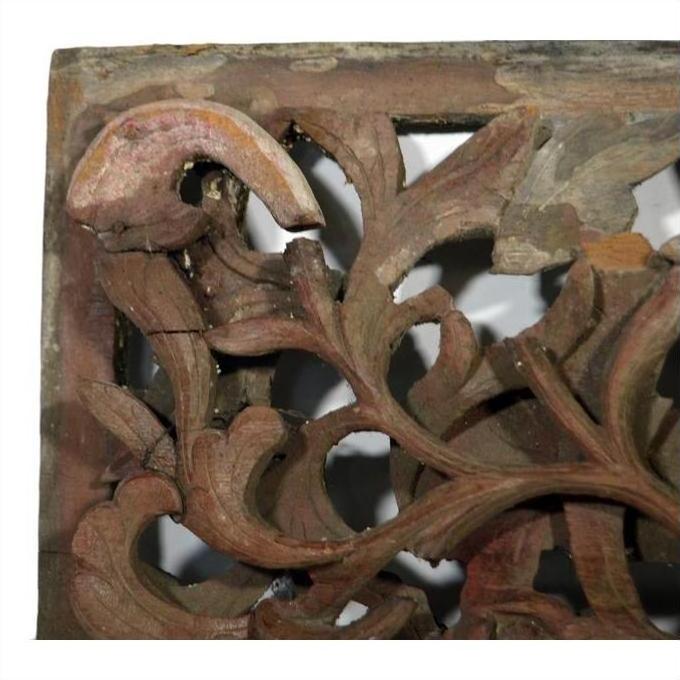 Brown wood antique Chinese temple carving close-up with detailed floral and leaf patterns.