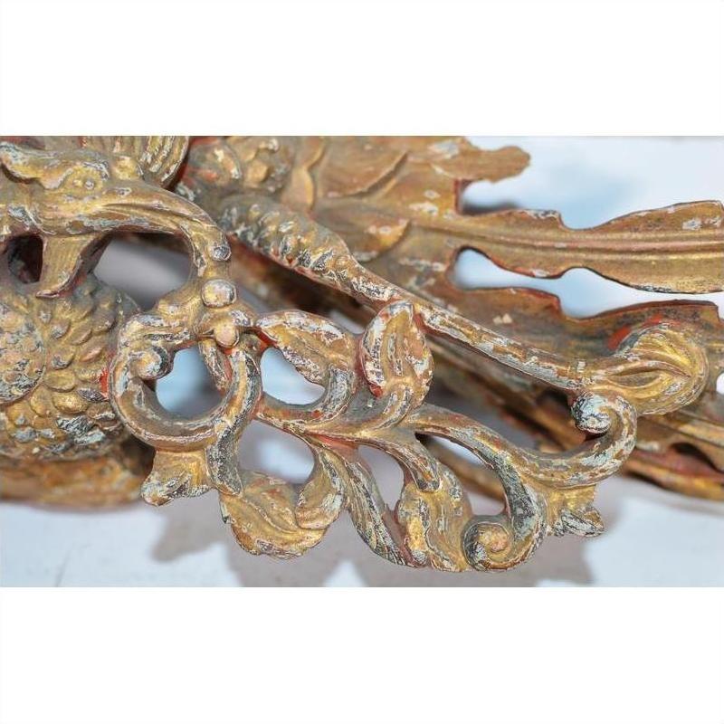Close-up of weathered gold wood Chinese temple carving with intricate floral and bird motifs.