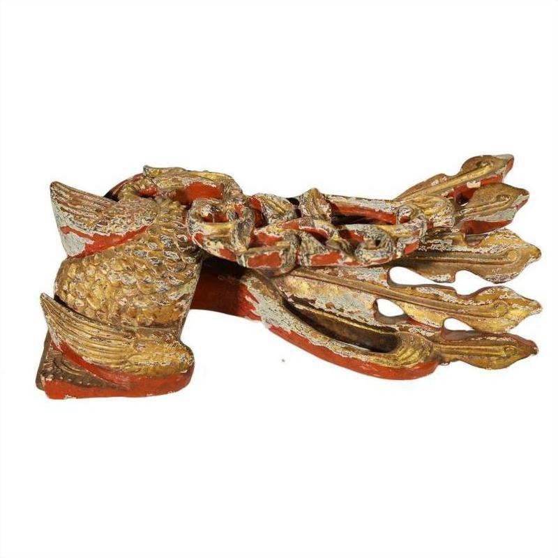 Close-up of a gold and red painted wooden fish carving with decorative accents, antique Chinese temple art.
