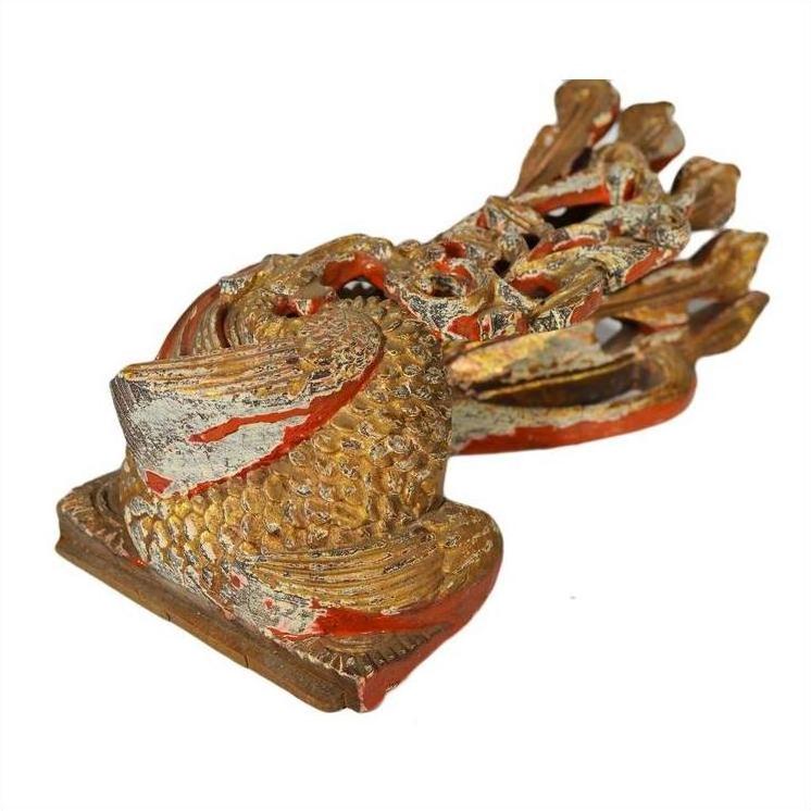 Gold and red carved dragon sculpture with textured, scaly surface, antique Chinese temple art, close-up view.