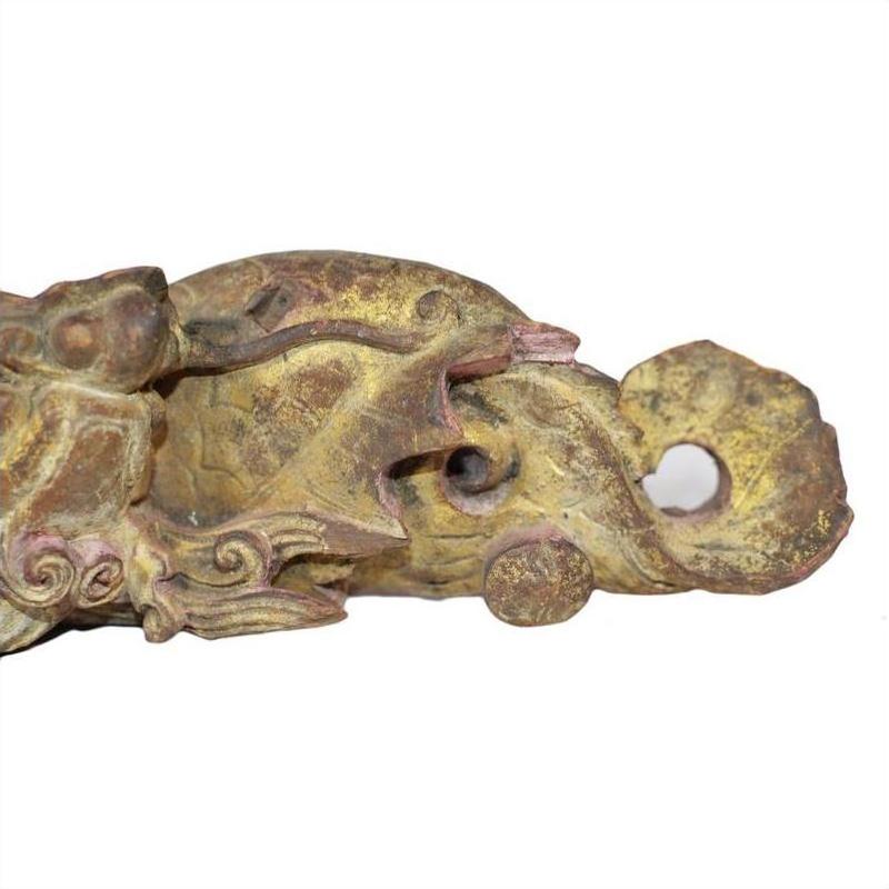 Close-up of antique bronze Chinese temple carving with intricate dragon details and weathered surface.