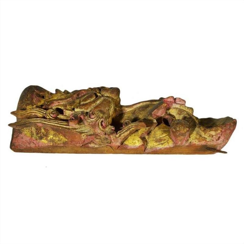 Gilded and red-painted wood dragon carving, antique Chinese temple art, side view on white background.