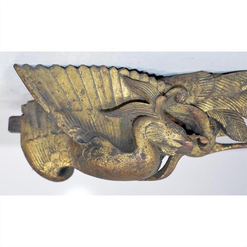 Gold wood bird carving with elaborate wings, antique Chinese temple art, mounted on white background, close-up view.