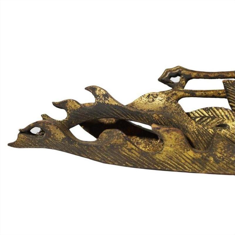 Close-up of brass dragon temple carving with weathered gold finish on white background.