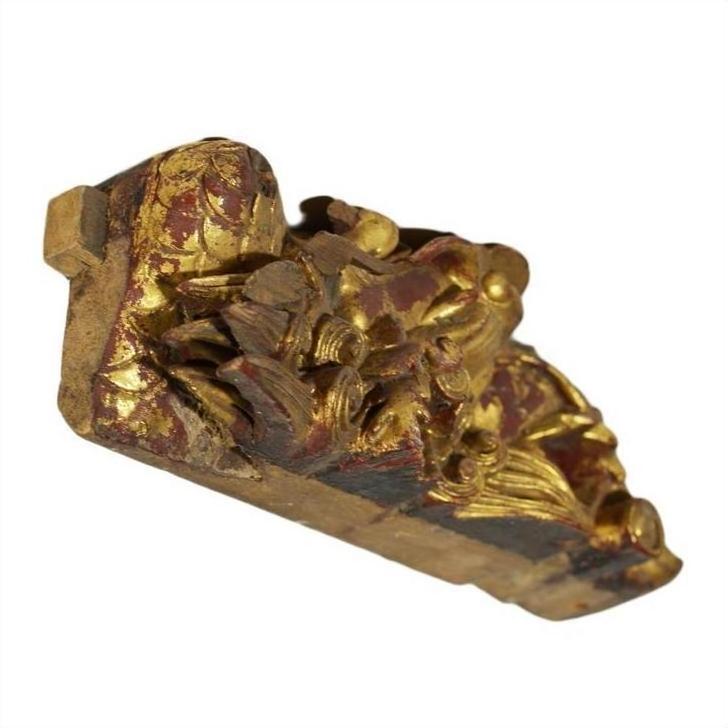 Close-up of gilded wood Chinese temple carving with gold and red floral and leaf patterns.