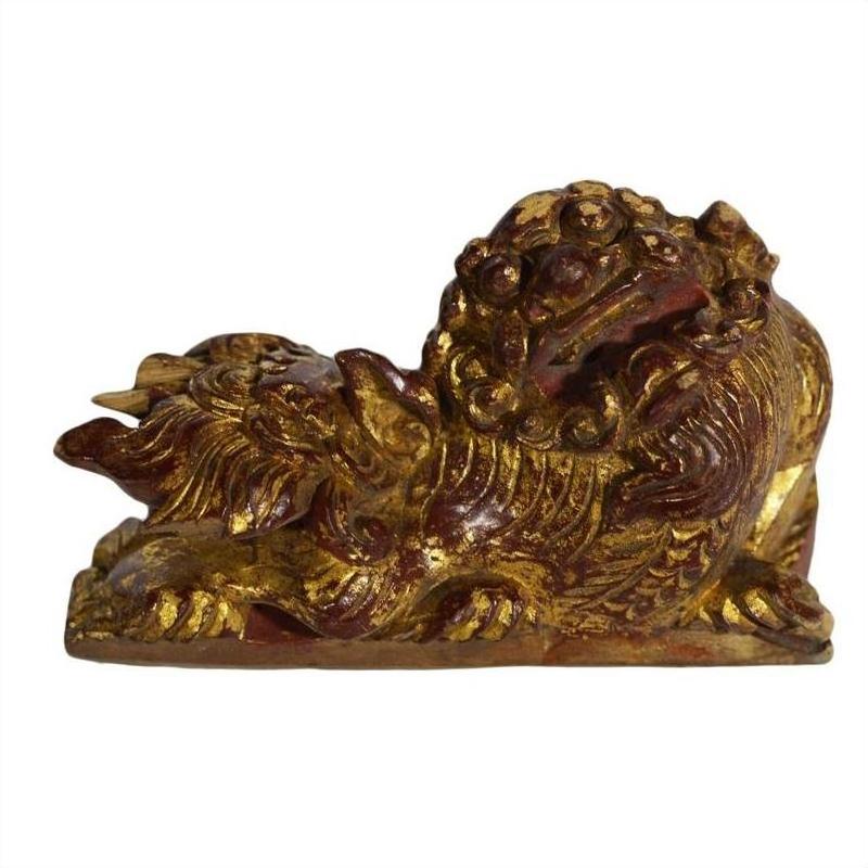 Close-up of antique Chinese wood temple carvings with intricate dragon shapes and fierce expressions, side by side.