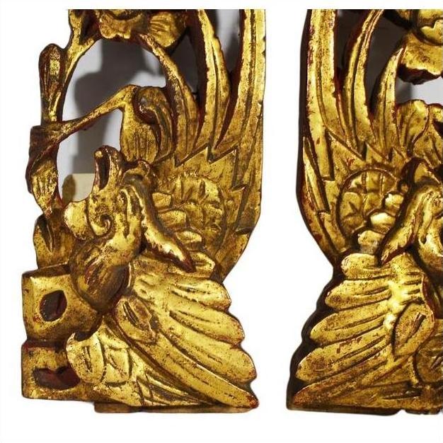 Close-up of ornate gold-painted wood Chinese temple carvings with intricate bird and floral designs.