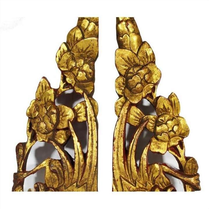 Gold and white wood temple carvings, pair, with intricate floral and leaf designs, close-up view.
