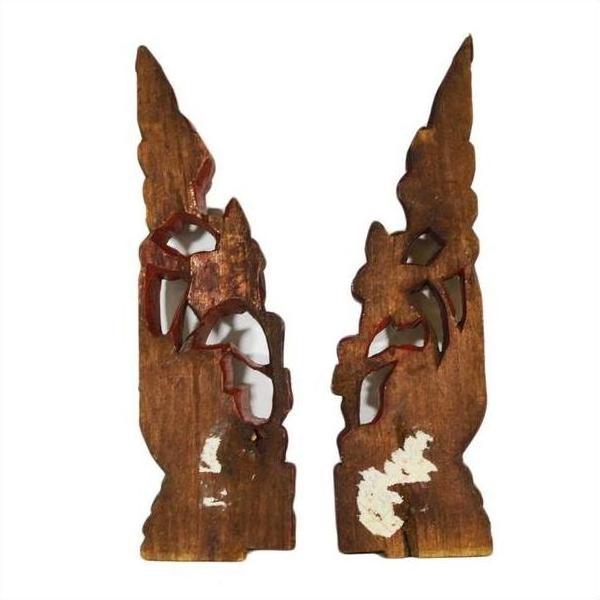 Brown wood antique Chinese temple carvings with pointed tops, decorative cutouts, and subtle white markings.
