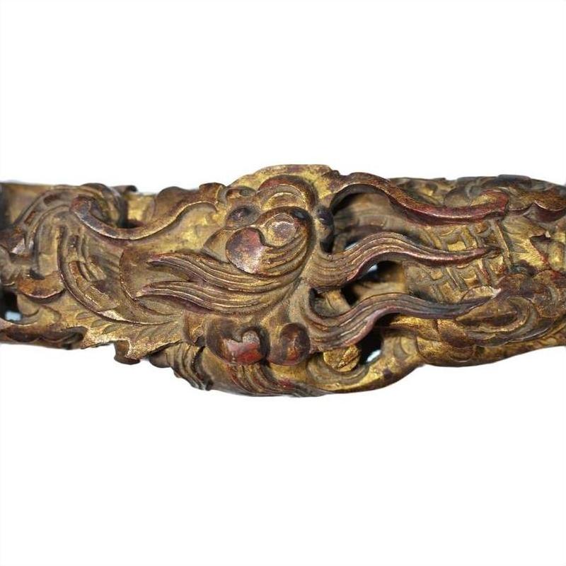 Gold-brown carved wood Chinese temple sculptures with swirling finish and stylized mythical creatures, close-up view.